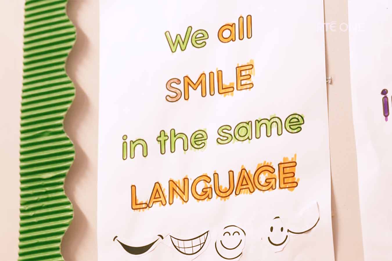 A hand drawn poster that says We all smile in the same language