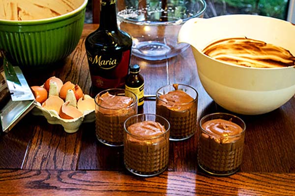 Four chocolate mousses needing a whipped Baileys cream topping