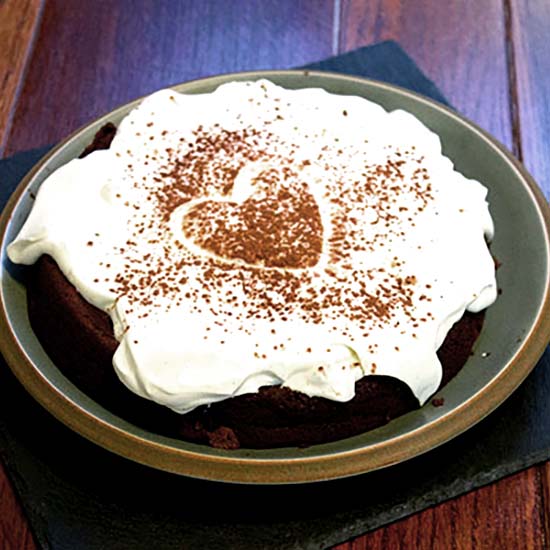 Chocolate Prune Cake with a topping of yoghurt and cream, and a dusting of cocoa