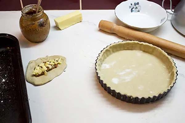 Pastry lined pie tin and leftover pastry made into a small cheese and chutney pie