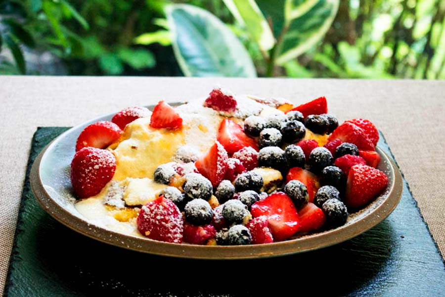lemon souffle omelette with fresh berries and a dusting of icing sugar