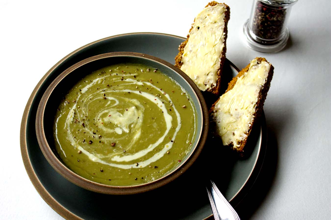 marrowfat pea soup with a swirl of creme fraiche and cracked black pepper