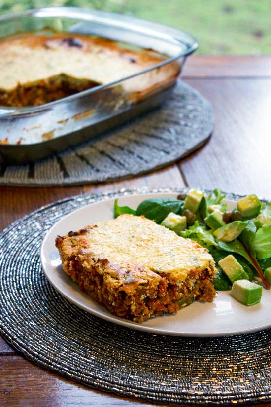pasta-less-lasagna-slice with salad in foreground lagagne pie in background